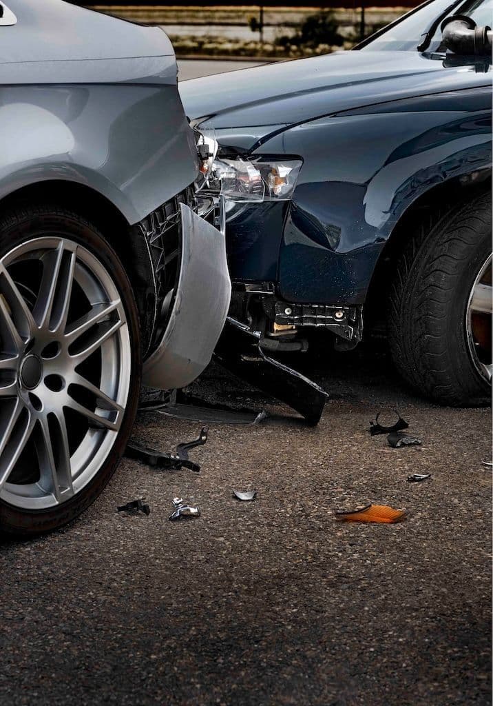 Two damaged vehicles in the aftermath of a car accident.