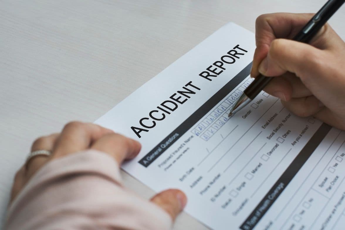 Someone filing an accident report in Florida with pen and paper.