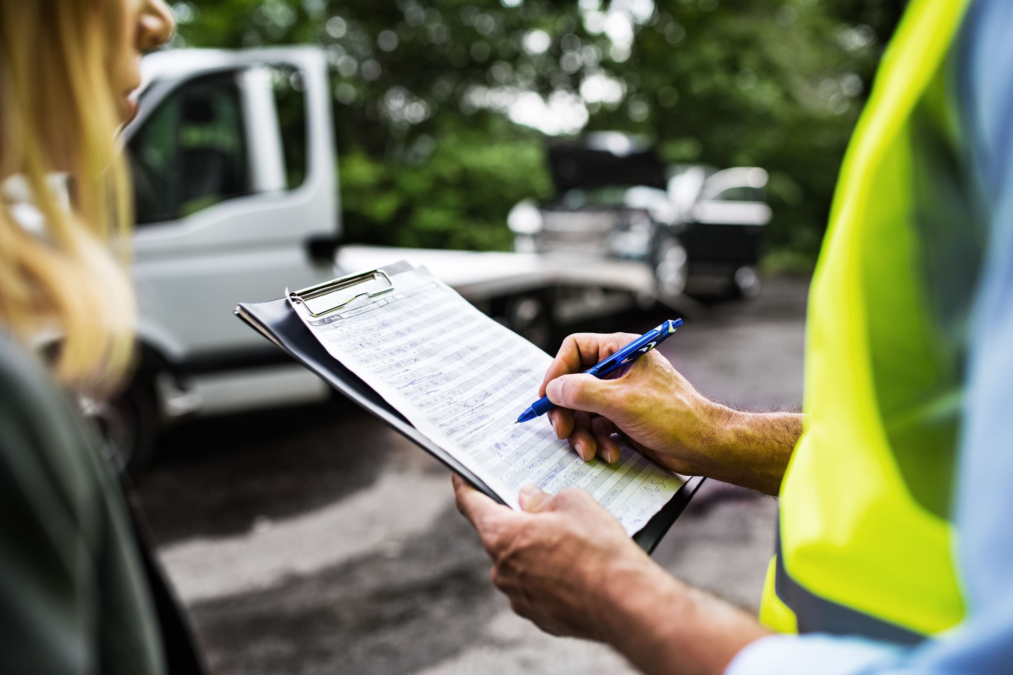 An auto accident victim, protected by Florida accident report privilege, speaking to an officer with a clipboard.