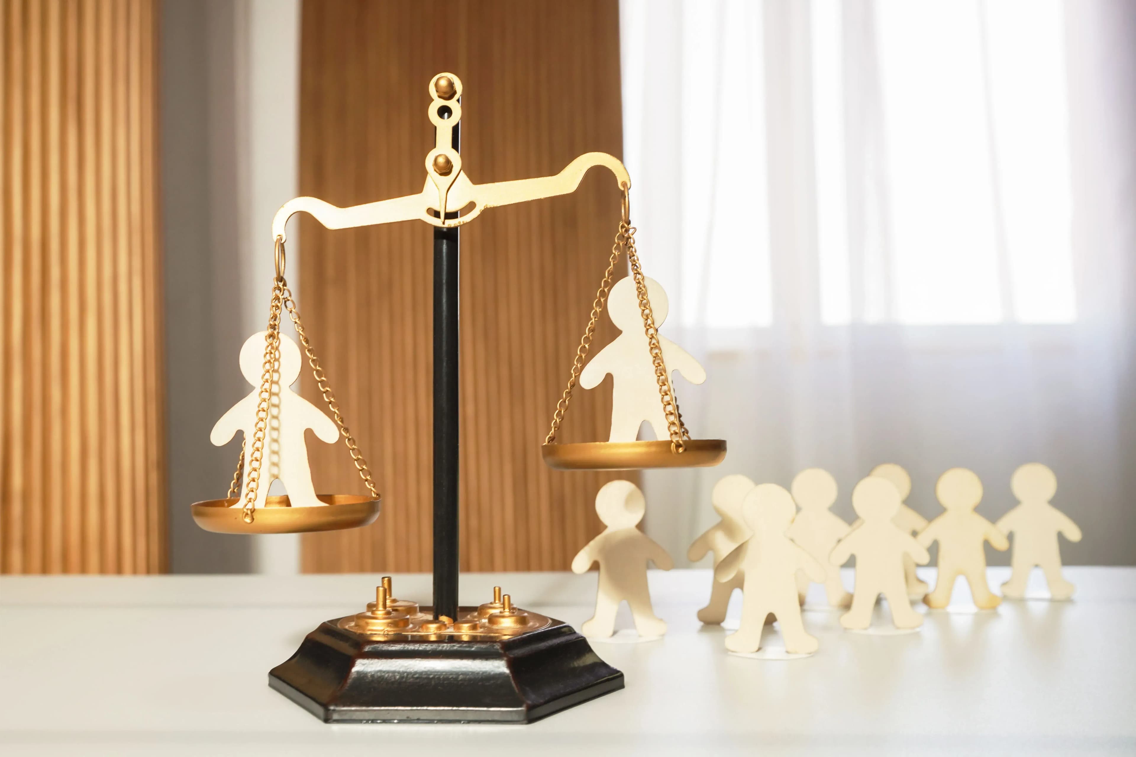 Figures weighed on a scale, illustrating how Oregon's negligence law weighs each person’s fault to determine compensation.